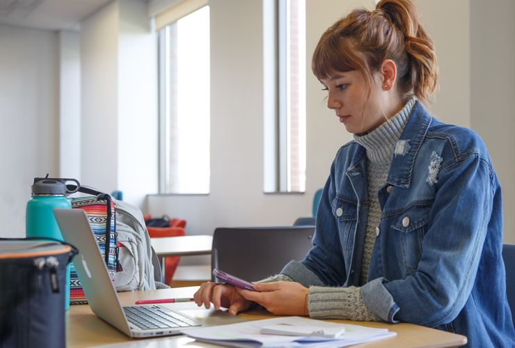 student at desk with laptop