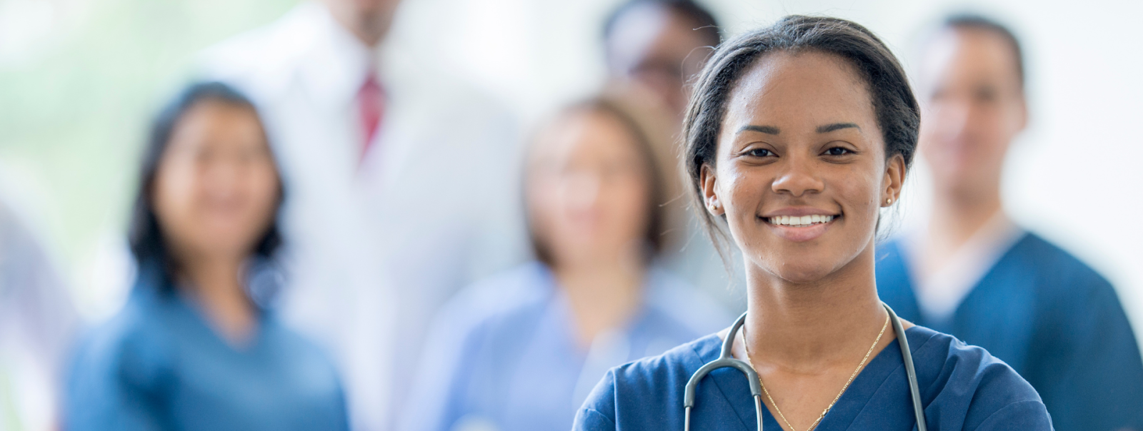 Nurse posing and smiling in front of medical colleagues